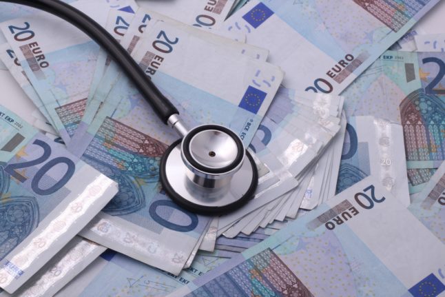 A stethoscope lies on banknotes.