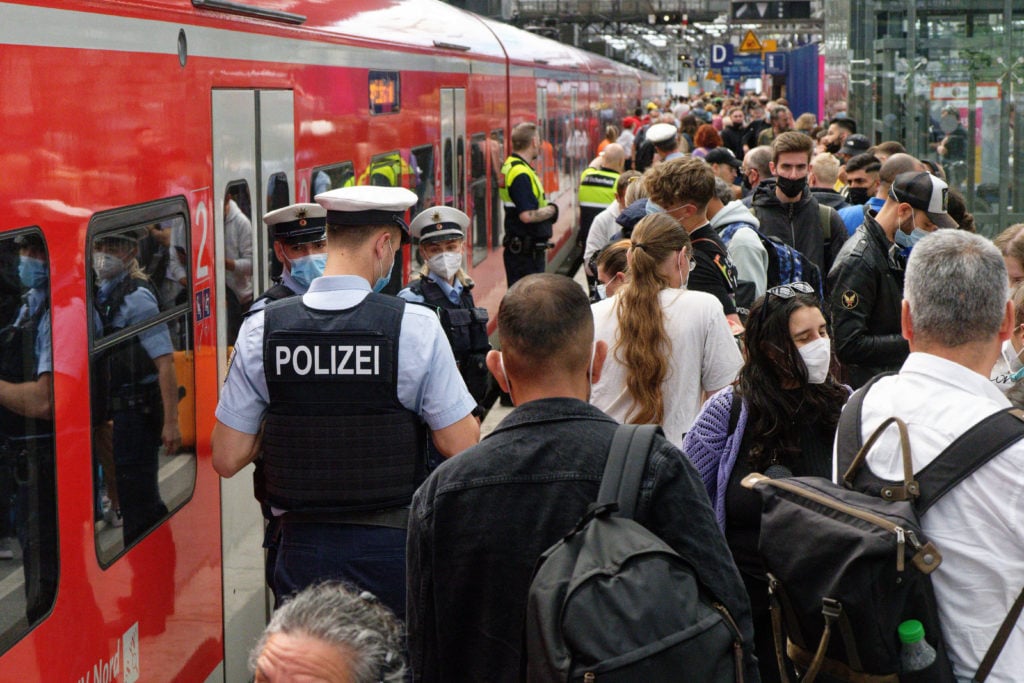 Police and Deutsche Bahn employees direct travellers on a crowded platform at the main station in Cologne on Monday.