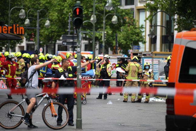 Emergency workers stand on a cordoned-off street after the car crash in Berlin.