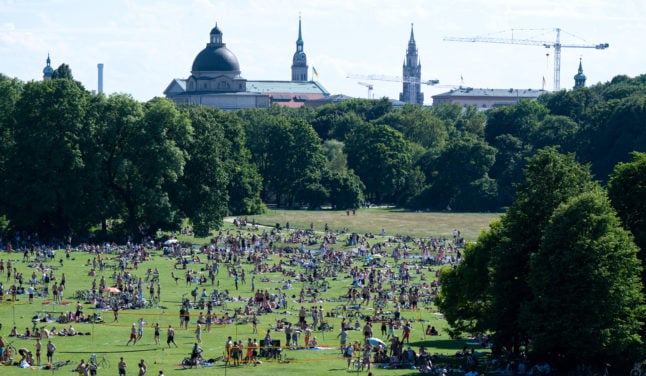 People enjoy the sunshine in Munich's English Garden. Experts are warning of a summer Covid wave.