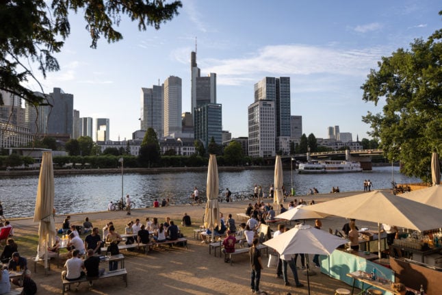 People sit on the banks of the Main river in Frankfurt.