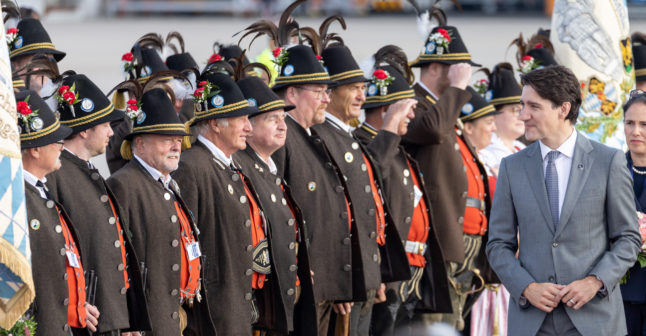 Justin Trudeau, Prime Minister of Canada, walks past people wearing traditional Bavarian costume after his arrival at Munich airport on June 26th.