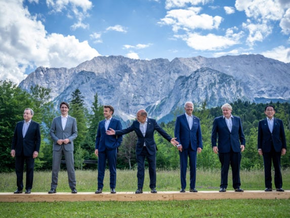 German Chancellor Olaf Scholz signals to the other G7 leaders during a photo shoot at Elmau. 