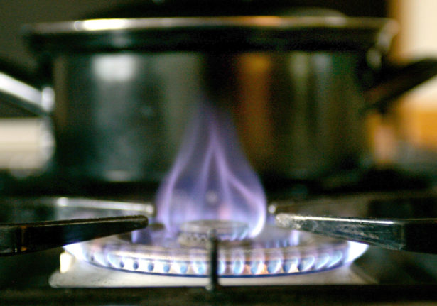 A lit gas hob on an oven