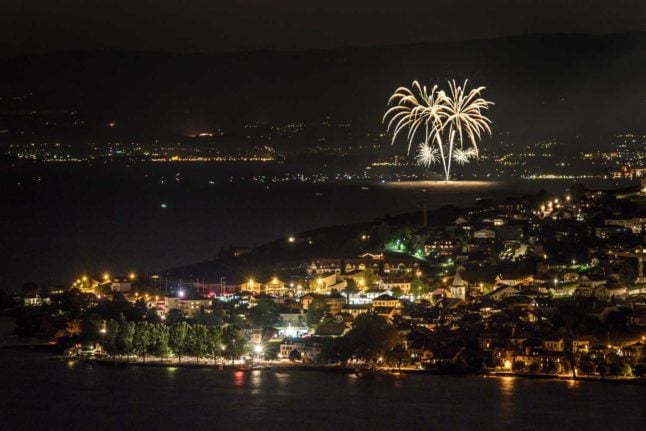 Fireworks are seen behind the village of Cully on the shore of Lake Geneva during the commemoration of Swiss National Day, on August 1, 2018. Photo: FABRICE COFFRINI / AFP