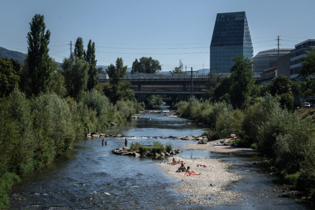 People cool off in Basel during a Swiss heatwave. Photo by Fabrice COFFRINI / AFP