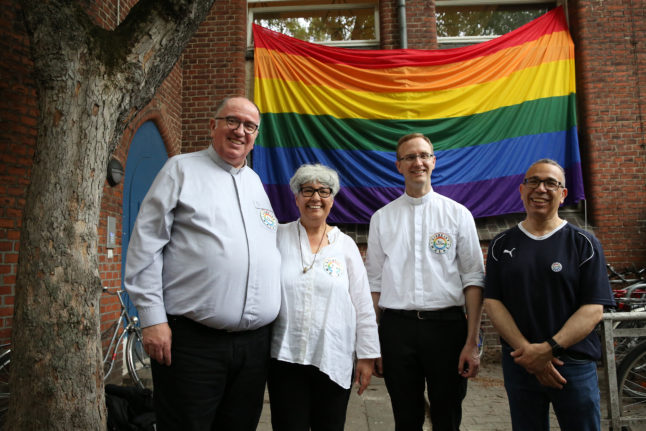 Members of the religious community stand in front of a rainbow flag after it was hoisted outside the Ibn Rushd-Goethe mosque in Berlin, Germany on July 1st 2022.
