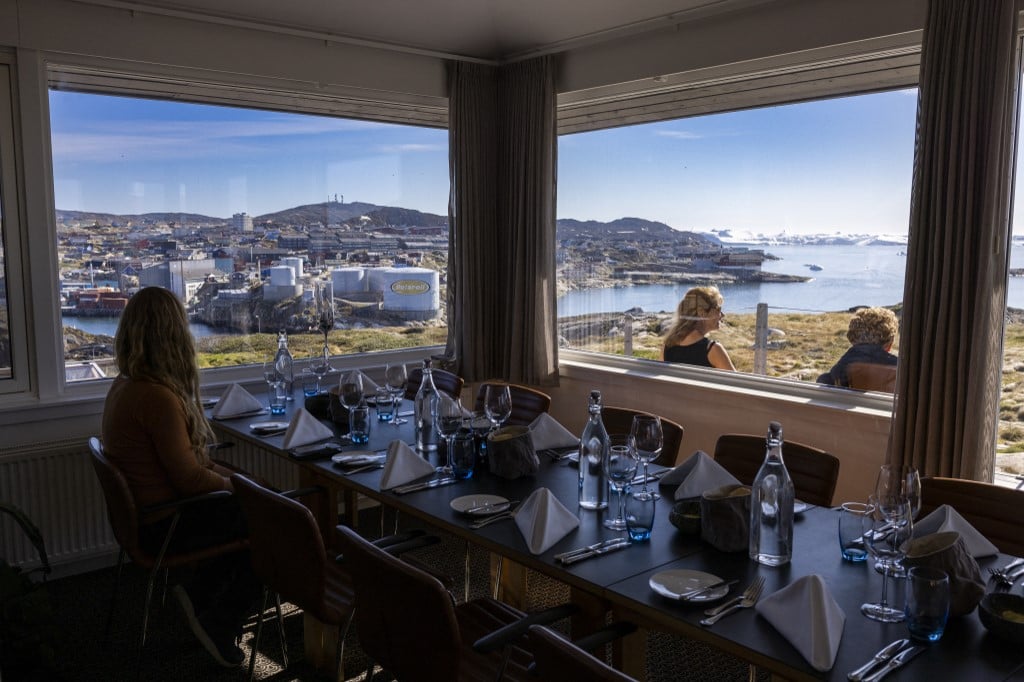 People get seated in a restaurant overlooking Disko Bay in Ilulissat, western Greenland, on 30th June, 2022.