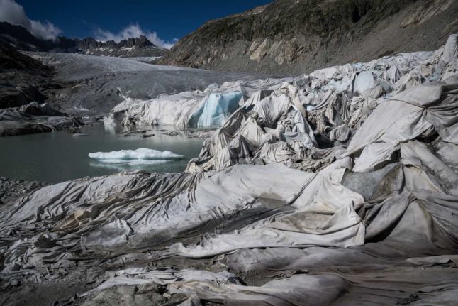 This photograph taken near Gletsch, in the Swiss Alps, on July 8, 2022 shows insulating foam covering a part of the Rhone Glacier to prevent it from melting. Photo: Fabrice COFFRINI / AFP
