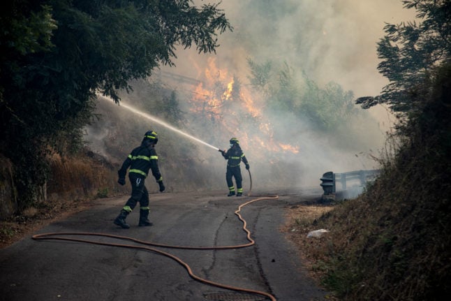Firefighters try to put down a fire near the city of Massarosa, central Italy, on July 20, 2022.