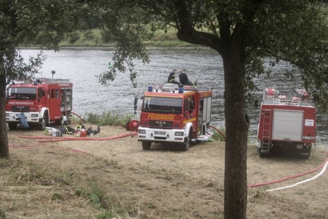 Firefighters rest as their engines refill with water