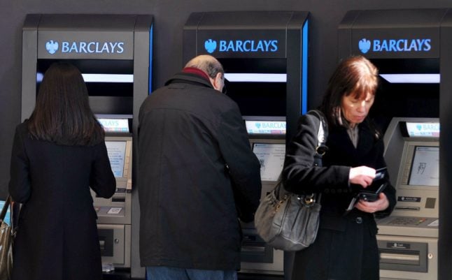 Archive photos show customers using Barclay ATM machines in London.