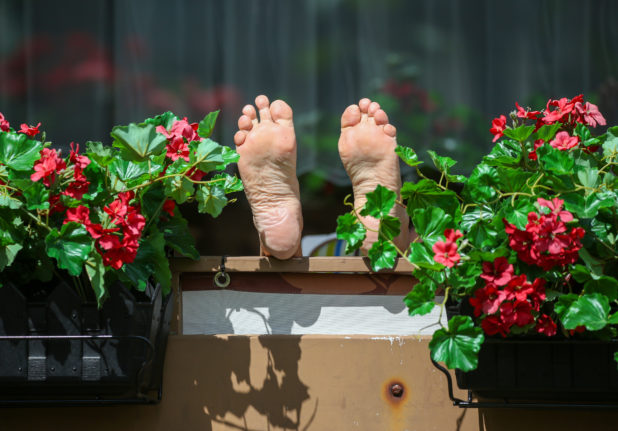 Woman sunbathing on balcony in Germany