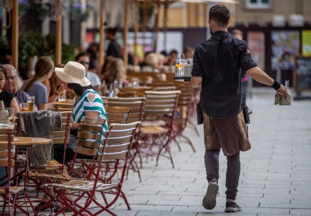 People sit at a cafe in Stuttgart in August 2021.