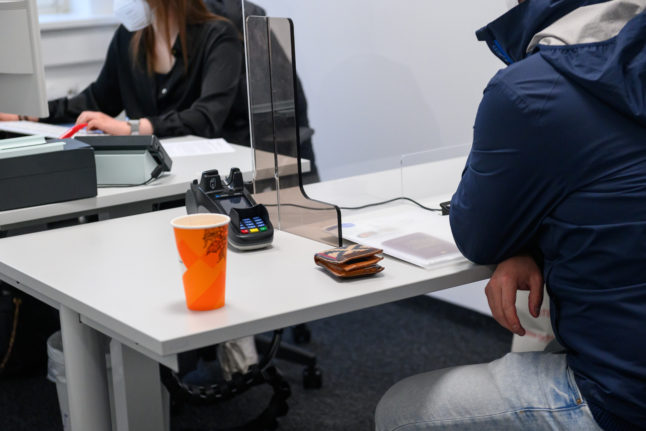 A staff member at a Hamburg immigration office helps a member of the public.