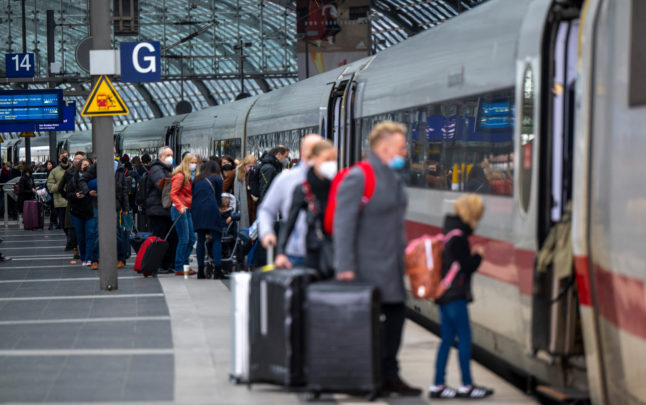 People board a train in Berlin in May 2022. People in Germany are still required to wear a medical face mask on public transport and on planes.