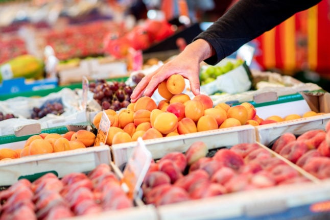 A customer looks at fruit at a weekly market in Oldenburg.