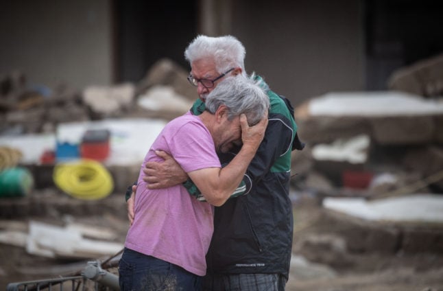 Brothers Bernd and Gerd Gasper hold each other in front of their flood-damaged parent's house in Altenahr-Altenstadt a few days after the flood disaster.