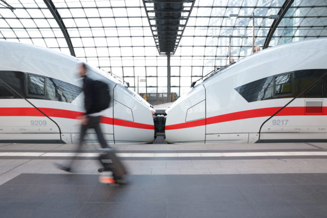 A traveller walks past a German ICE high speed train.