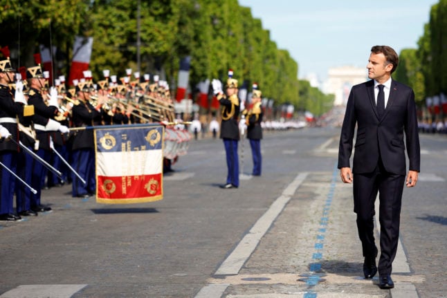 French President Emmanuel Macron reviews troops during the Bastille Day military parade on the Champs-Elysees avenue in Paris on July 14, 2022.
