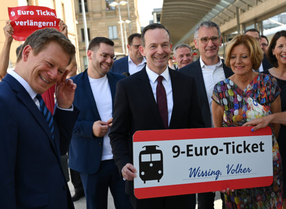 On the sidelines of the train launch of Deutsche Bahn's 100th ICE 4, Transport Minister Volker Wissing holds a €9 ticket presented to him by an environmental activist next to Malu Dreyer (SPD), state premier of Rhineland-Palatinate, and Richard Lutz (l), CEO of Deutsche Bahn (DB).