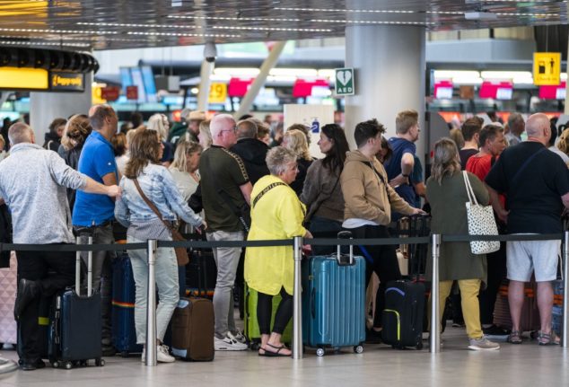 Amsterdam, Schiphol Airport: passengers queueing.