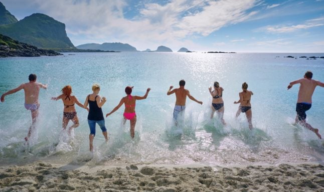 Pictured are people at a beach in north Norway.