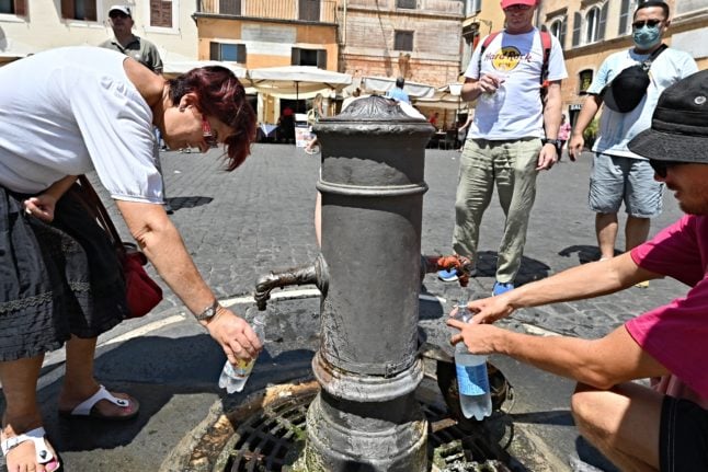 Tourists fill their bottles from a 'nasone'.
