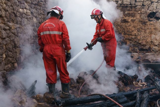 Firefighters douse smouldering rubbles in a burnt house in spain