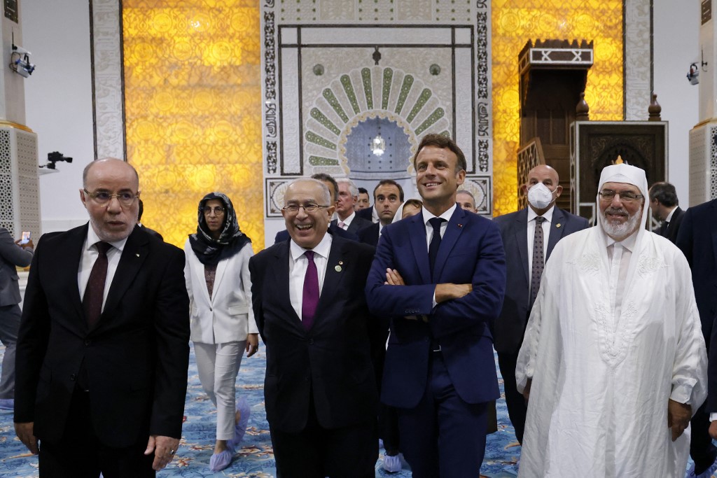 French President Emmanuel Macron (3rd R), Algerian Foreign Affairs Minister Ramtane Lamamra (2nd L) and imam of the Great Mosque of Algiers Mohamed Mamoun El-Kacimi El-Hassani (R) visit the Great Mosque of Algiers