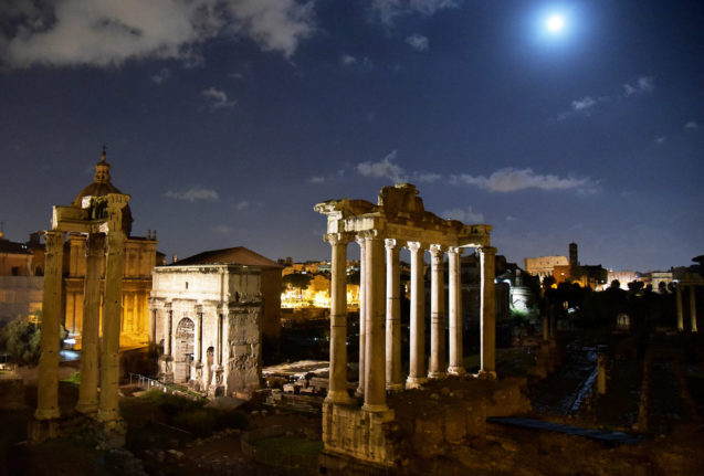 The moon rises on Rome's ancient forum. 