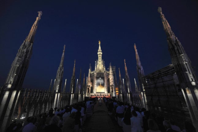 The roof of Milan's duomo cathedral illuminated for a nighttime concert.