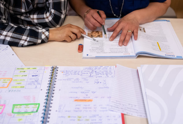 Students study from a textbook at a school in Munich