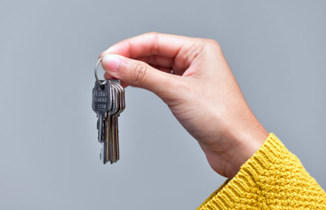 A person holds a pair of keys for a flat.