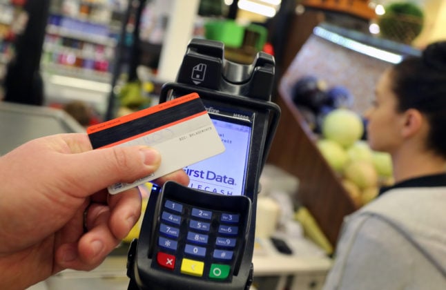 A person pays with an EC card at a German supermarket.