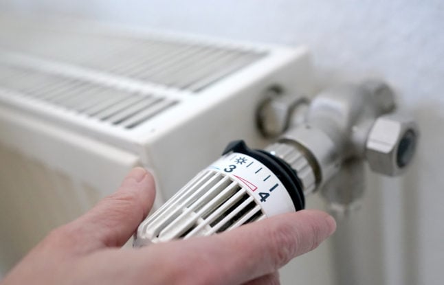 A person turns down the radiator in Germany. Gas bills are set to rise significantly.