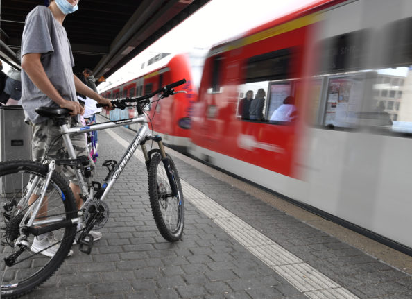 A cyclist waits for a regional train in Cologne