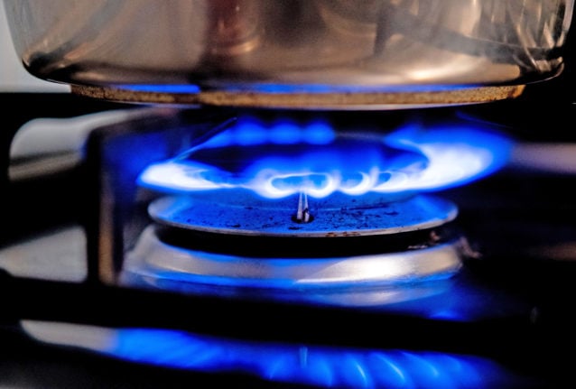 A gas flame burns on a kitchen stove in an apartment.