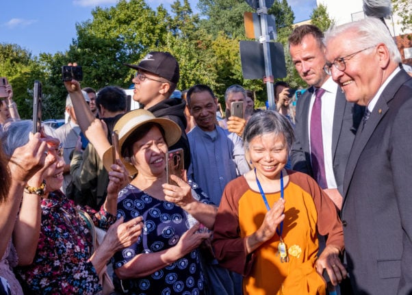 German President Frank-Walter Steinmeier is greeted by residents after his visit to a Buddhist-Vietnamese temple in the Lichtenhagen district of Rostock.