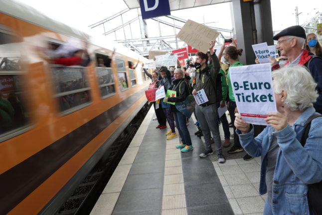 Demonstrators stand with banners in support of the €9 ticket in front of an arriving train at Gesundbrunnen station in Berlin.