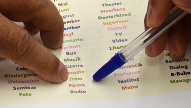 Refugees from Afghanistan practice reading German words at the state library in Potsdam in 2016.