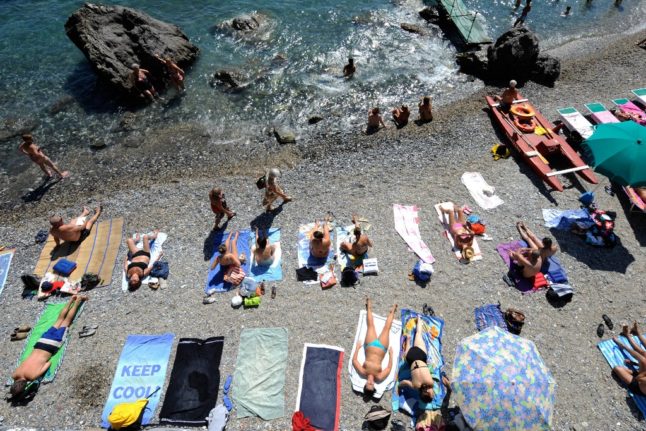 Beachgoers sunbathe at a public beach near Santa Margherita Ligure, Genoa