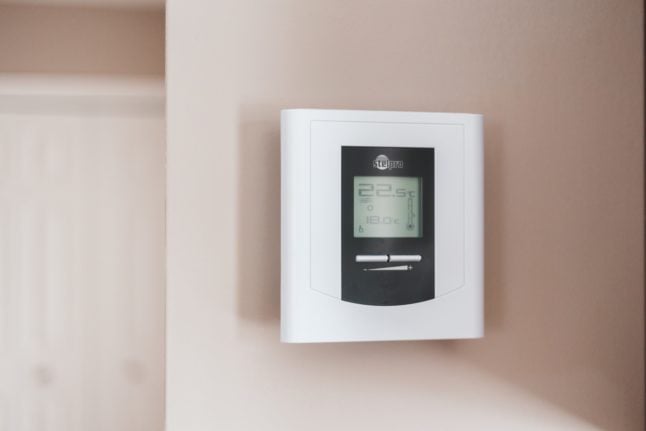 Pictured is a thermostat on a wall.