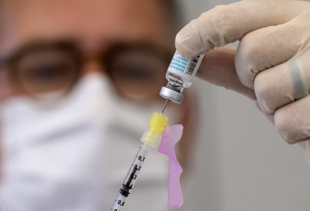 An employee at a Munich clinic with a dose of the vaccine from Bavarian Nordic.