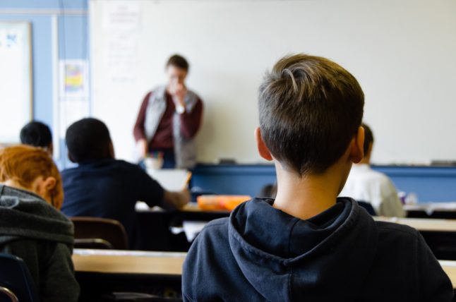 Pictured is a boy in a classroom.