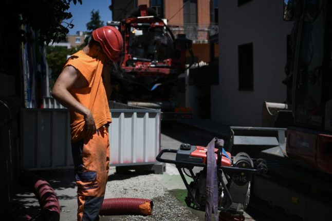 Construction worker wiping sweat off his brow.