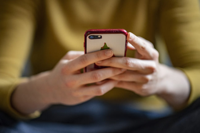 A person holds a mobile phone in Germany.