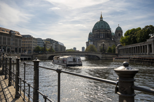 A tourist boat sails along the Spree next to Museum Island.