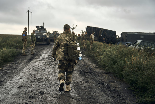 Ukrainian soldiers stand on a country road in the liberated territory in the Kharkiv region on Monday September 12th.