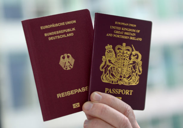 A person holds a German and British passport.